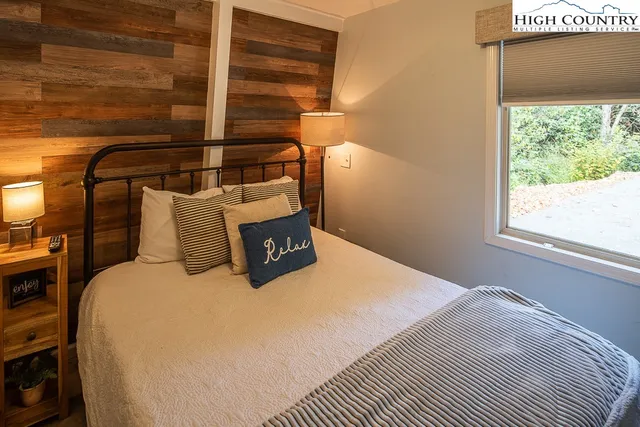 a bed sitting in a bedroom next to a window