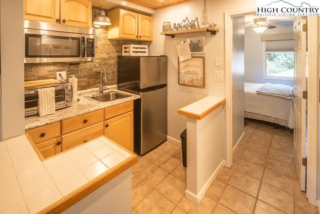 a kitchen with stainless steel appliances kitchen island granite countertop a refrigerator and a sink
