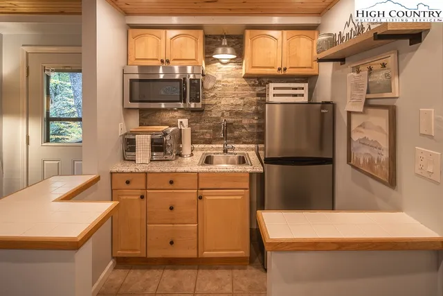 a kitchen with stainless steel appliances a refrigerator sink and microwave