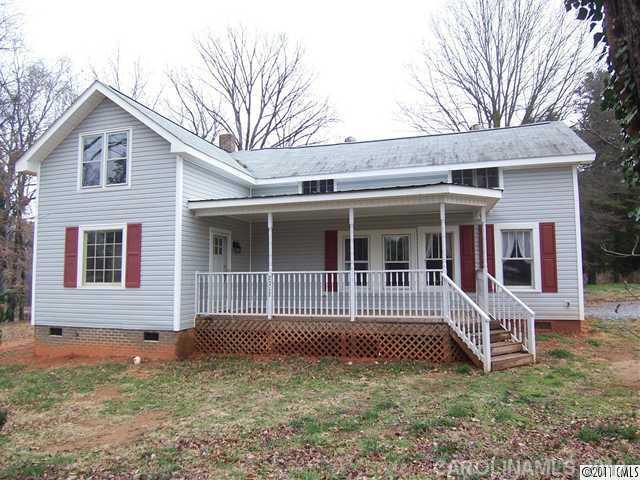 a view of front of a house with large windows and a yard