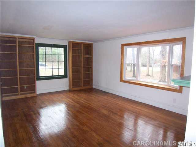 2717 Toddville Road Charlotte, NC 28214 - Photo 4 of 11 a view of an empty room with wooden floor and a window