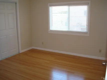 an empty room with wooden floor and a window