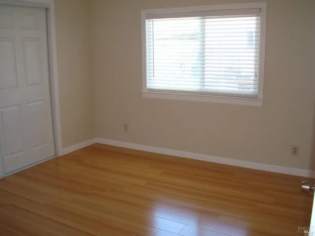 an empty room with wooden floor and a window