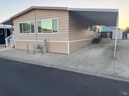 a view of a house with a patio and a yard