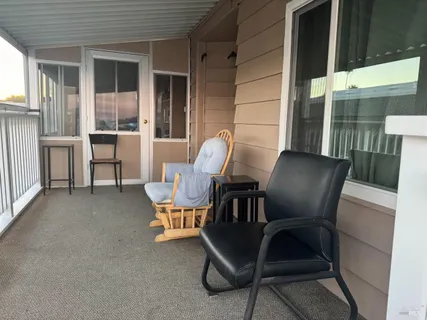 a view of a two chairs in the room and front view of a house