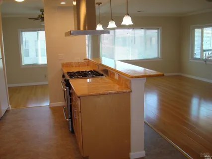 a kitchen with a stove and wooden floor