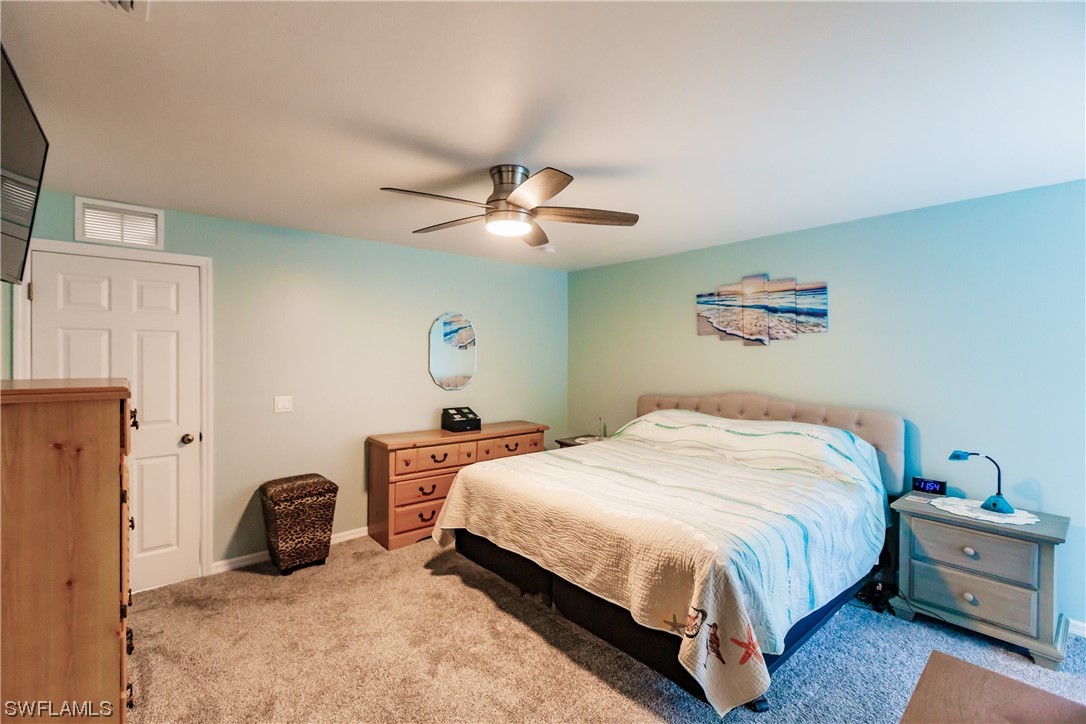 217 Manatee Street Fort Myers, FL 33913 - Photo 18 of 38 a bedroom with a bed and a chandelier