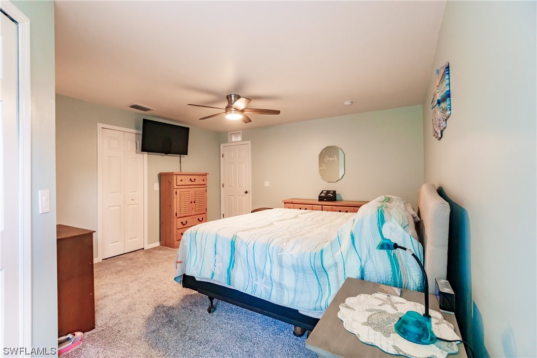 217 Manatee Street Fort Myers, FL 33913 - Photo 19 of 38 a bedroom with a bed and a chandelier