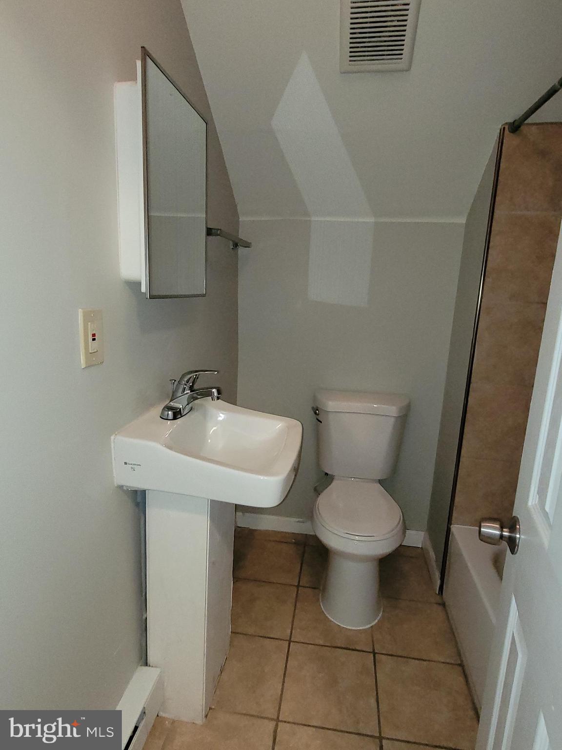 503 North Rodney Street, Unit 3A Wilmington, DE 19805 - Photo 17 of 18 a bathroom with a toilet sink and mirror