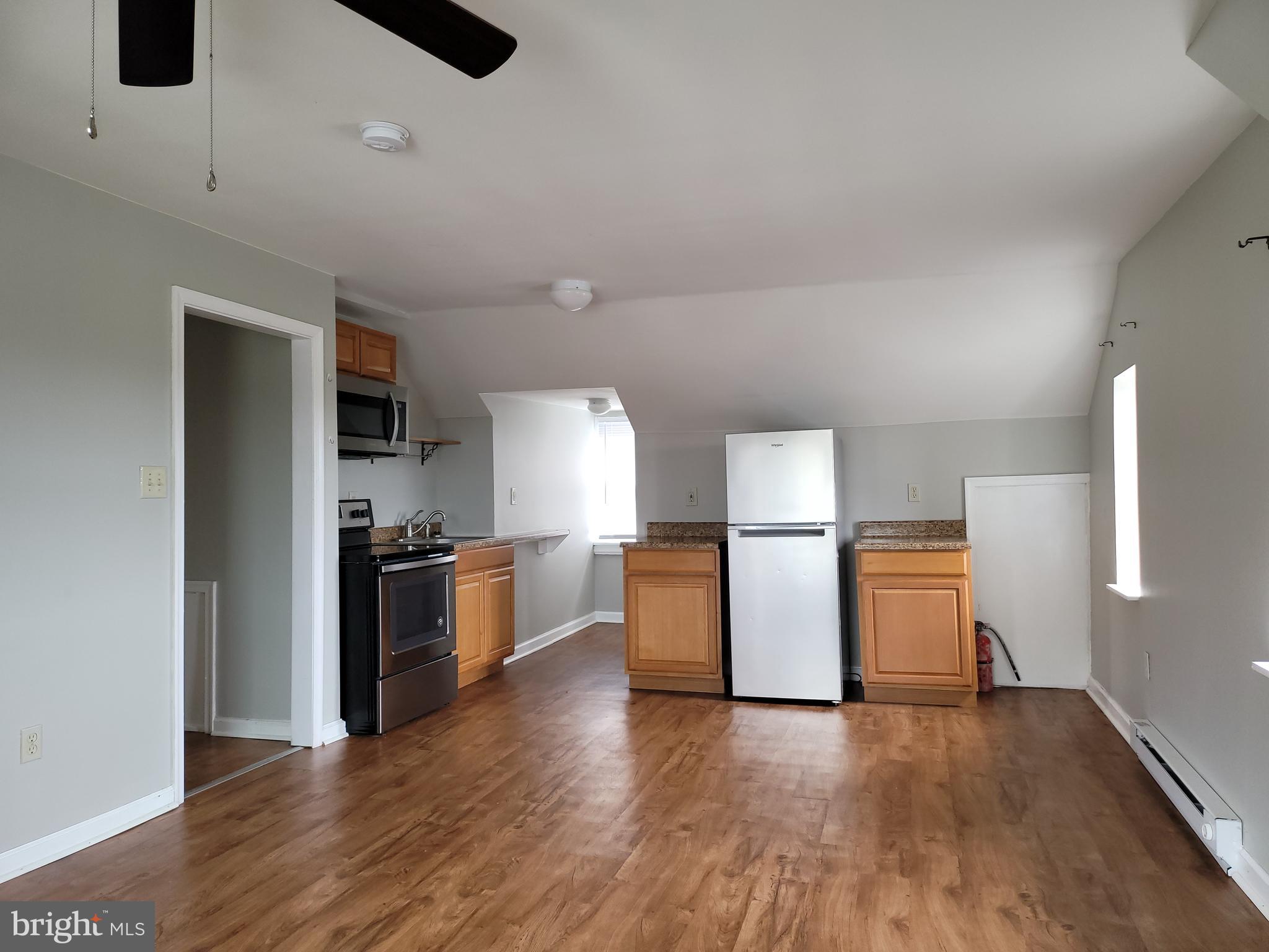 503 North Rodney Street, Unit 3A Wilmington, DE 19805 - Photo 4 of 18 a kitchen with a refrigerator and wooden floor