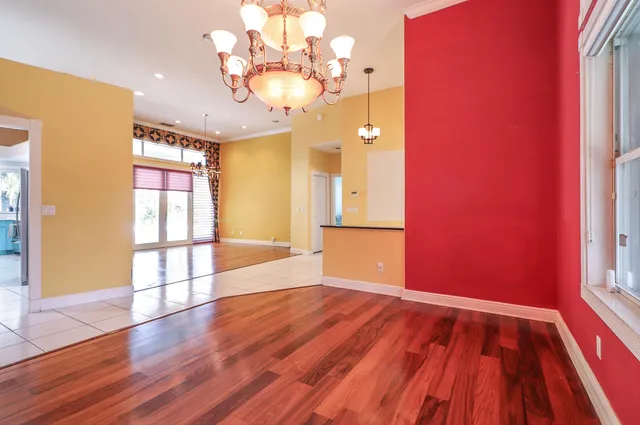 a view of a hallway with wooden floor and a living room