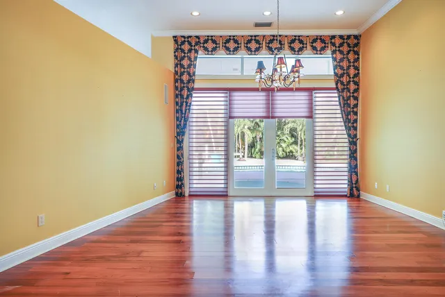 an empty room with wooden floor a fireplace and windows