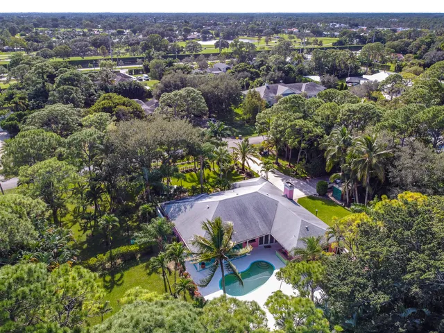 an aerial view of residential houses with outdoor space and trees