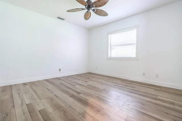 a bed sitting in a spacious bedroom next to a window