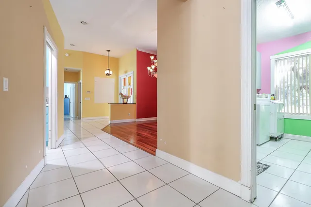 a palm tree sitting in front of a house with large trees