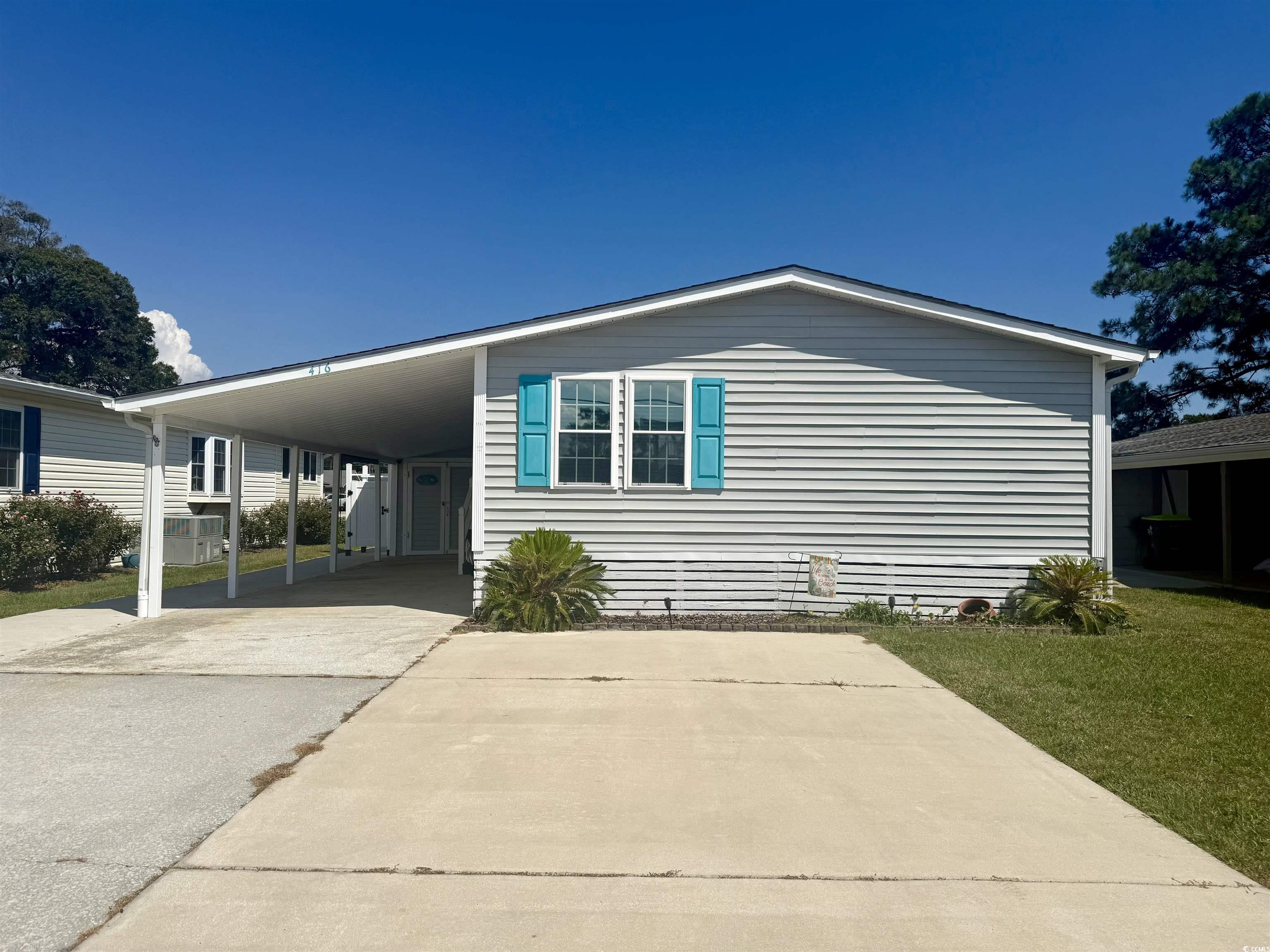 416 Oceanside Drive Surfside Beach, SC 29575 - Photo 1 of 37 Manufactured / mobile home featuring driveway, a carport, and a front lawn