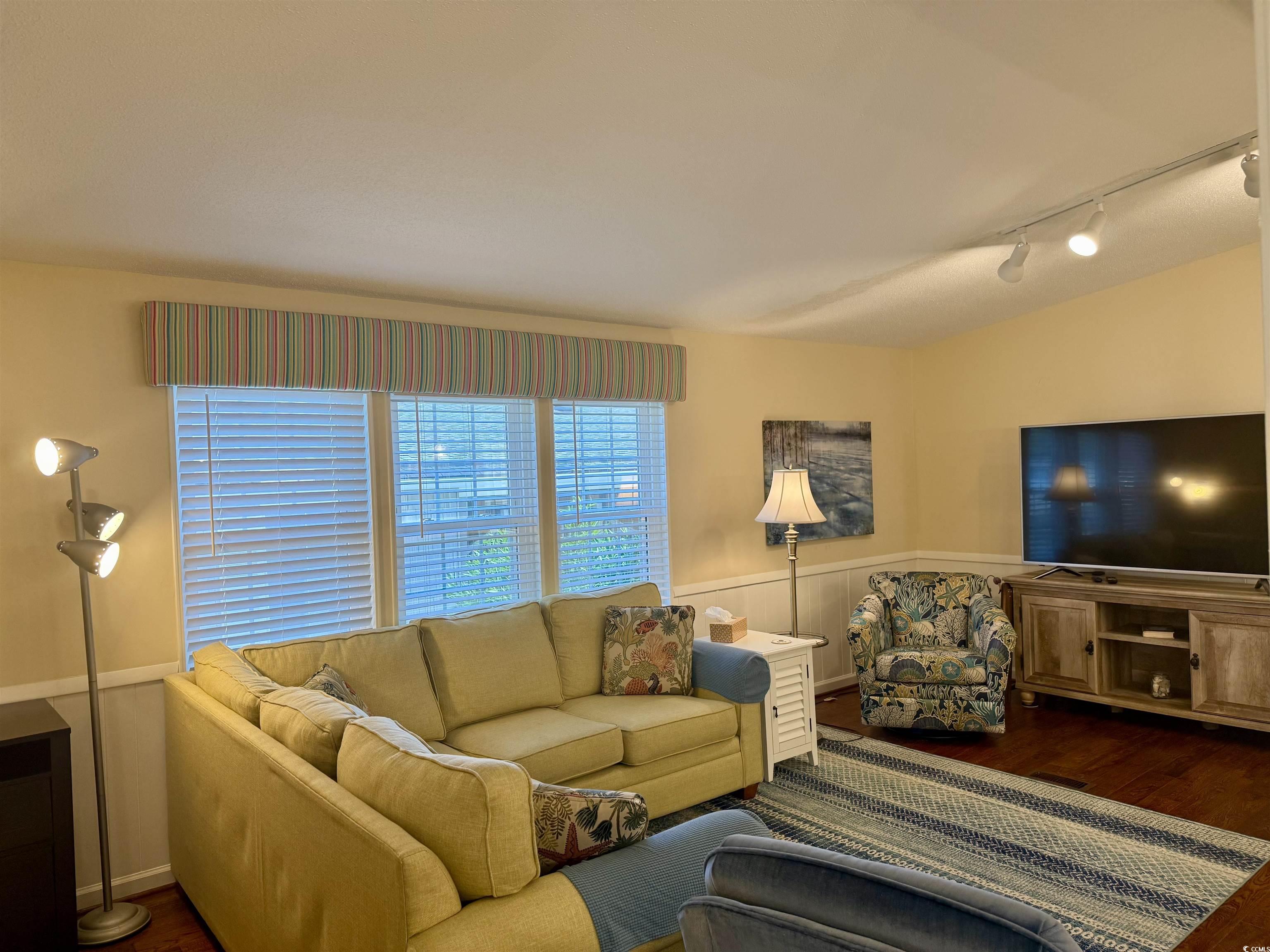 416 Oceanside Drive Surfside Beach, SC 29575 - Photo 16 of 37 Living area featuring track lighting, wood finished floors, and a wainscoted wall