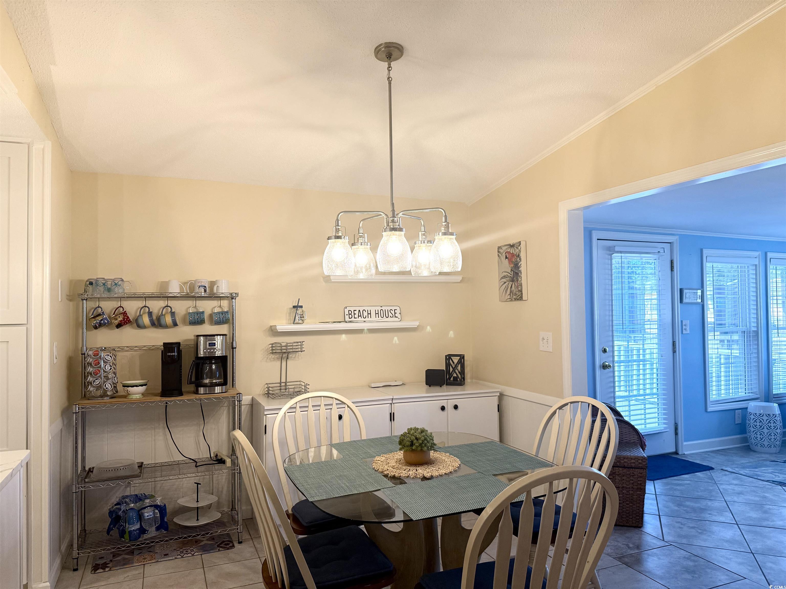 416 Oceanside Drive Surfside Beach, SC 29575 - Photo 7 of 37 Tiled dining room featuring lofted ceiling, a chandelier, and crown molding