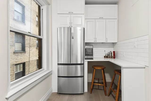 a kitchen with stainless steel appliances granite countertop a refrigerator and a stove top oven