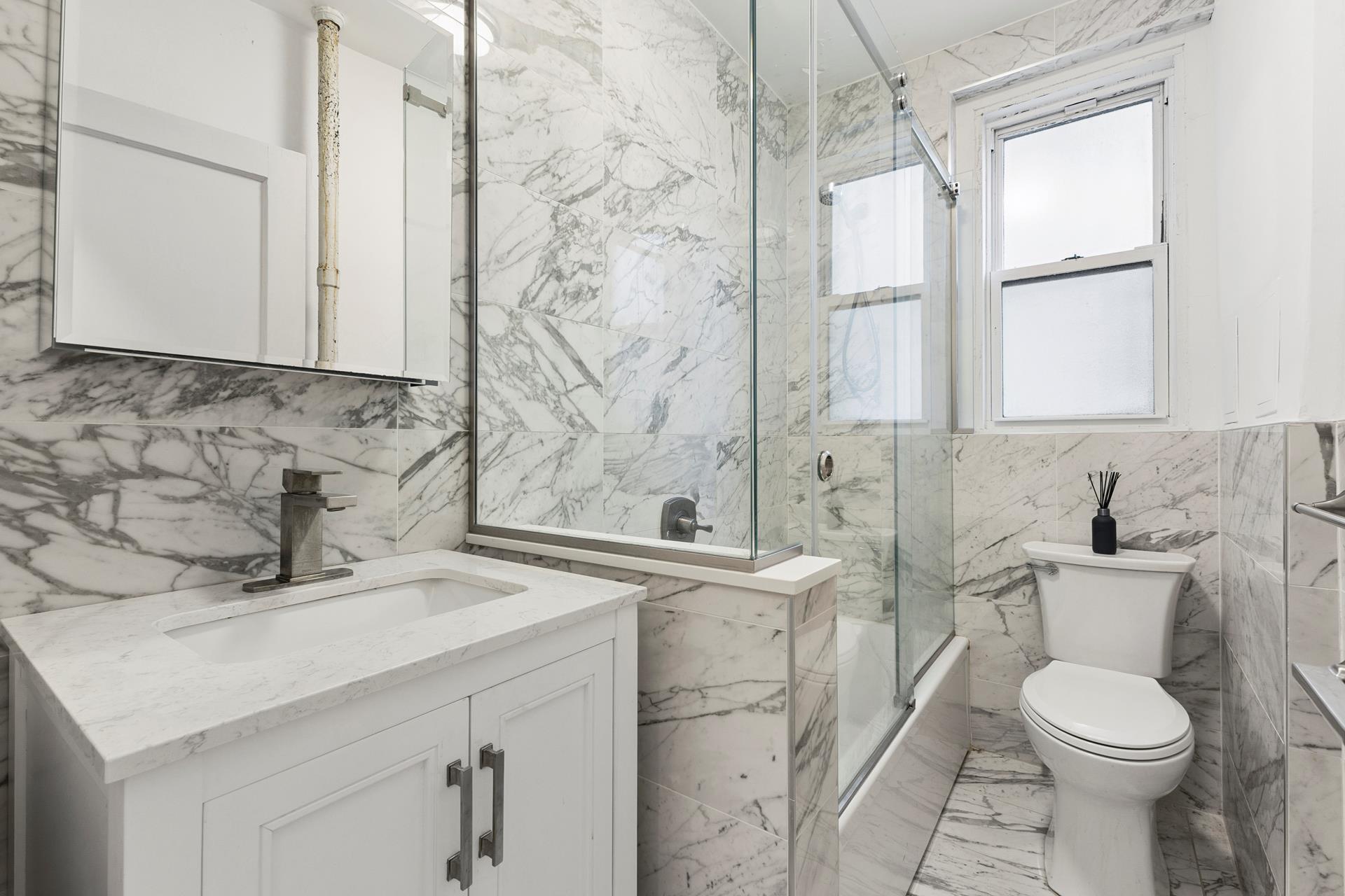 172 East 4th Street, Unit 6C Manhattan, NY 10009 - Photo 7 of 7 a bathroom with a sink a toilet and shower