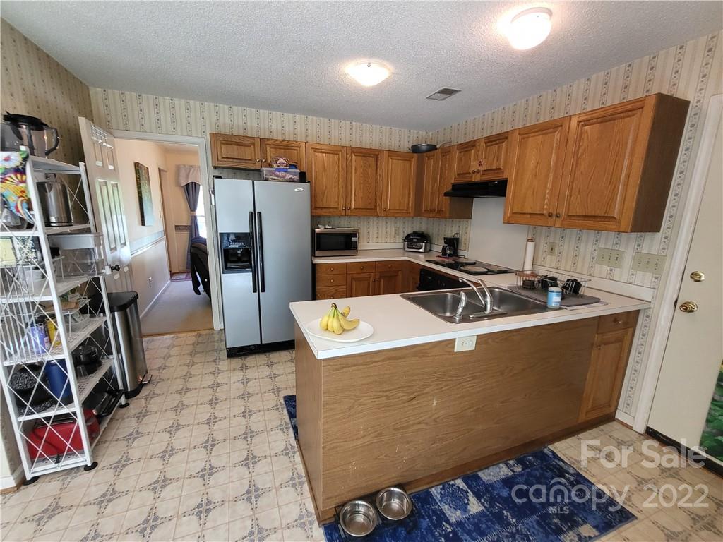 9216 Torrence Crossing Drive Huntersville, NC 28078 - Photo 20 of 34 a view of a kitchen with fridge and workspace