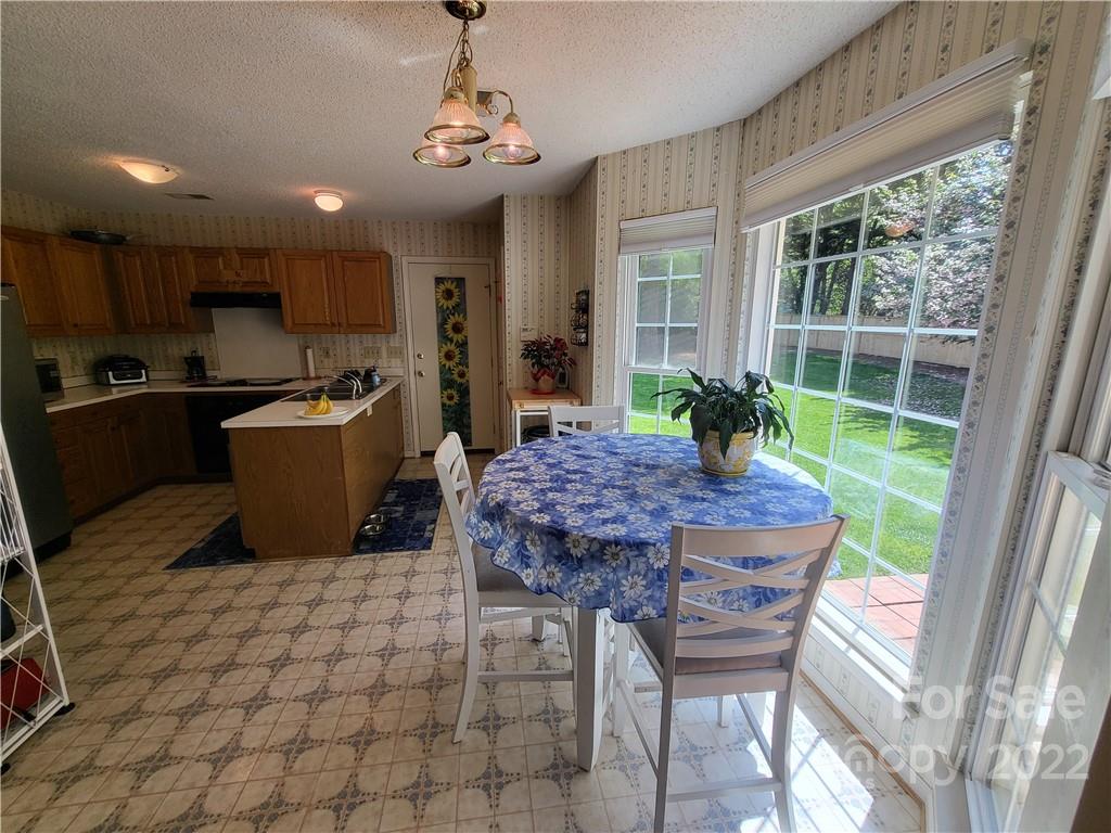 9216 Torrence Crossing Drive Huntersville, NC 28078 - Photo 21 of 34 a kitchen with a table chairs and wooden floor
