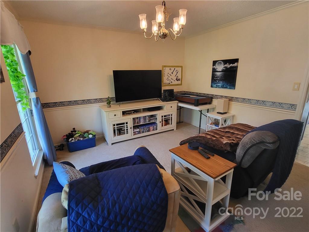 9216 Torrence Crossing Drive Huntersville, NC 28078 - Photo 5 of 34 a living room with furniture and a flat screen tv