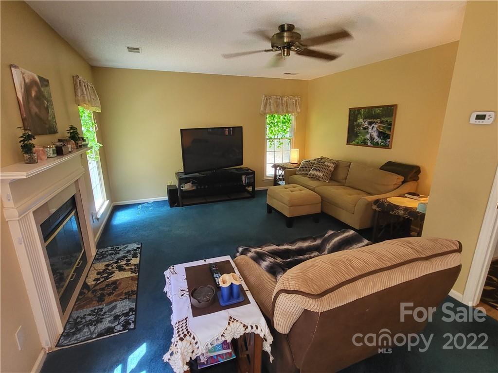 9216 Torrence Crossing Drive Huntersville, NC 28078 - Photo 9 of 34 a living room with furniture and a flat screen tv