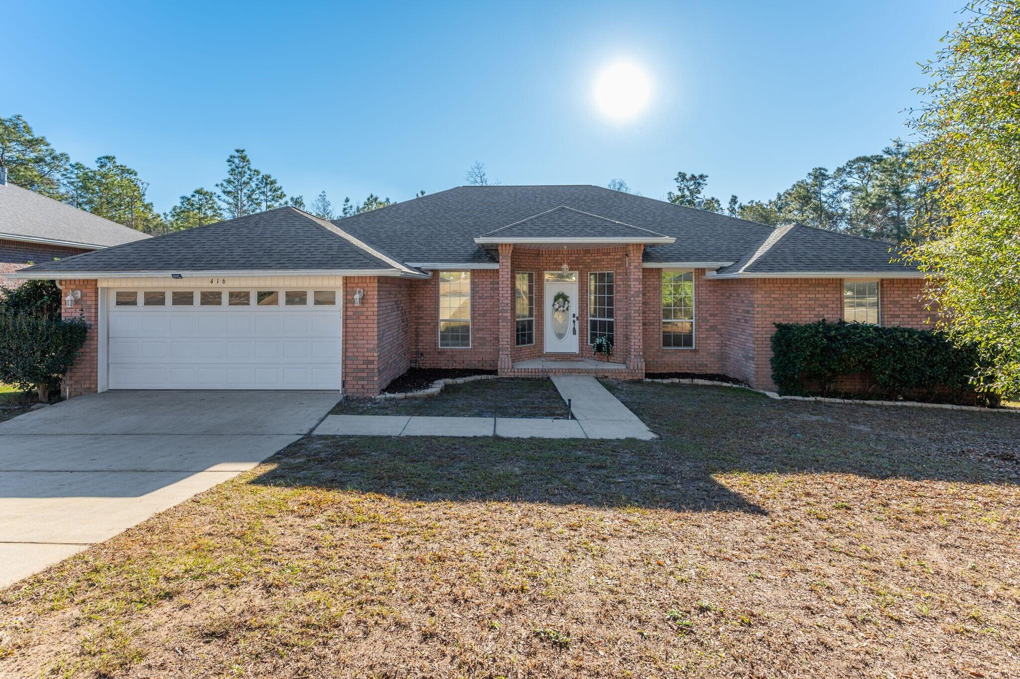 416 Swift Fox Run Crestview, FL 32536 - Photo 1 of 32 a front view of a house with a yard and a garage