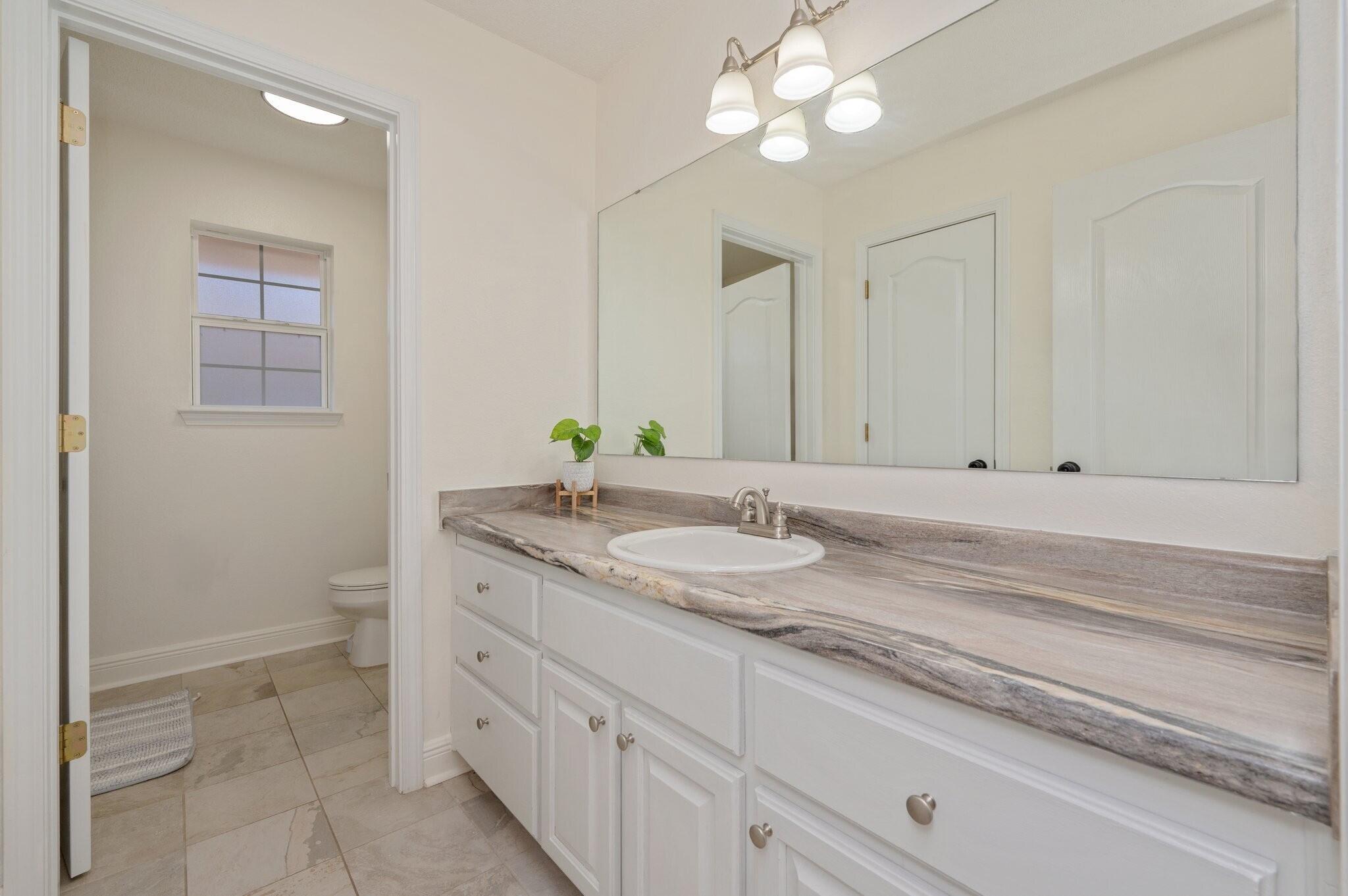 416 Swift Fox Run Crestview, FL 32536 - Photo 25 of 32 a bathroom with a granite countertop sink and a mirror