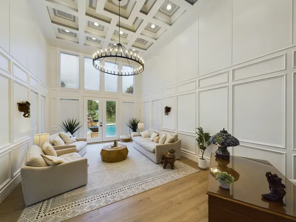 a living room with furniture a chandelier and a rug