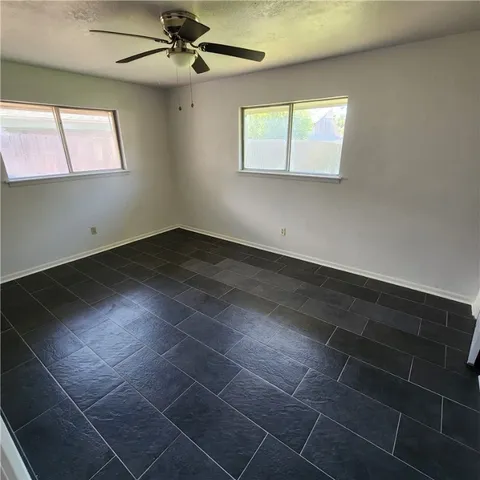 an empty room with windows and fan