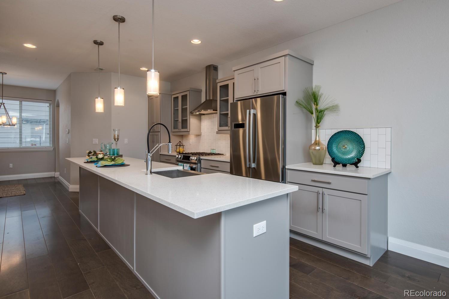 1571 Wolff Street Denver, CO 80204 - Photo 6 of 27 a kitchen with kitchen island white cabinets and refrigerator