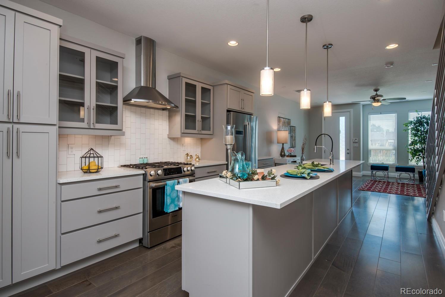 1571 Wolff Street Denver, CO 80204 - Photo 7 of 27 a kitchen with a stove a sink a center island and wooden floor