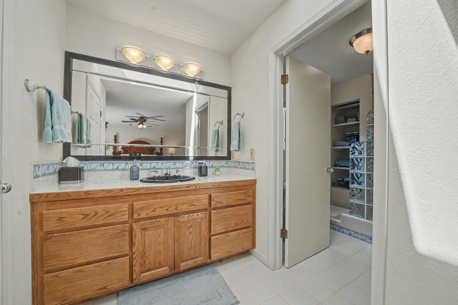 18299 West Clinton Road Jackson, CA 95642 - Photo 40 of 56 a bathroom with a granite countertop sink a mirror and a vanity