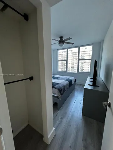 a living room with a floor to ceiling window and a flat screen tv