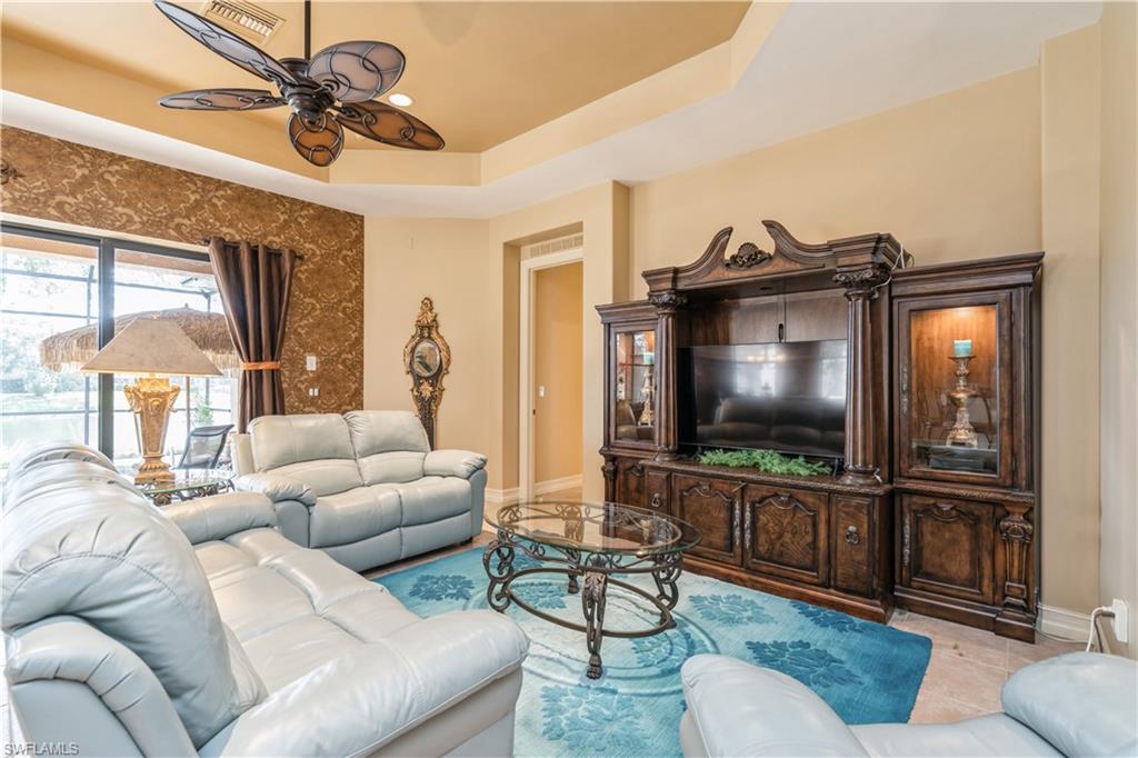 1411 Serrano Circle Naples, FL 34105 - Photo 20 of 50 Tiled living room with a tray ceiling and ceiling fan
