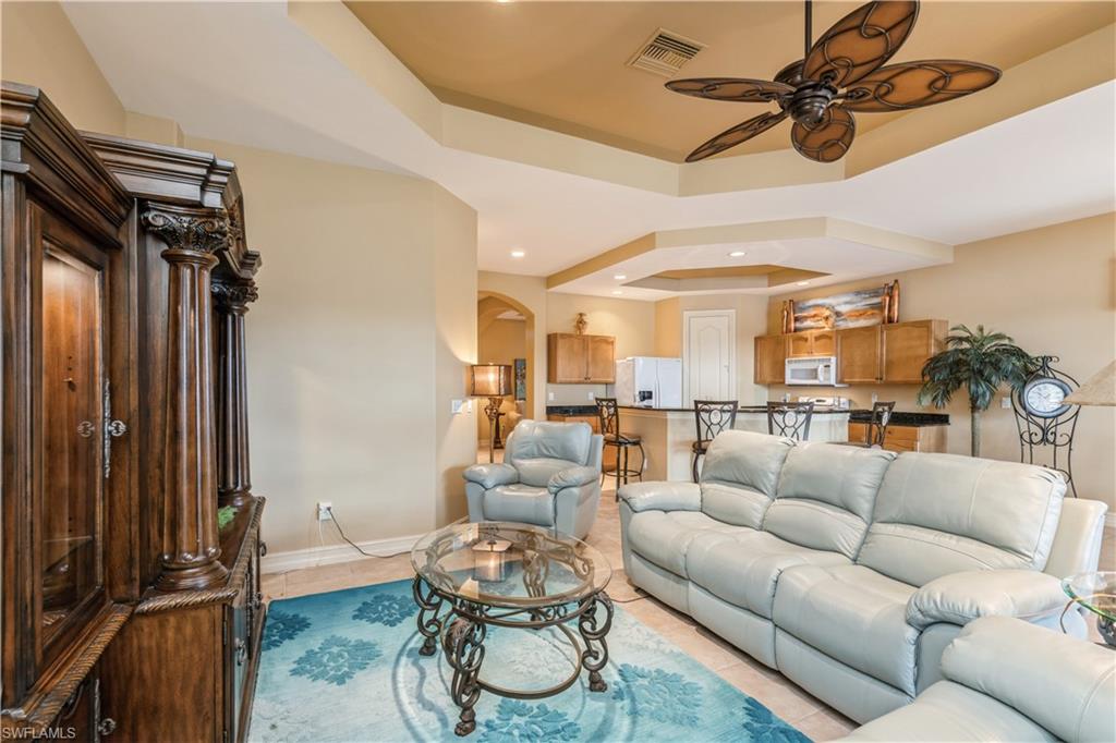 1411 Serrano Circle Naples, FL 34105 - Photo 23 of 50 Tiled living room with a tray ceiling and ceiling fan