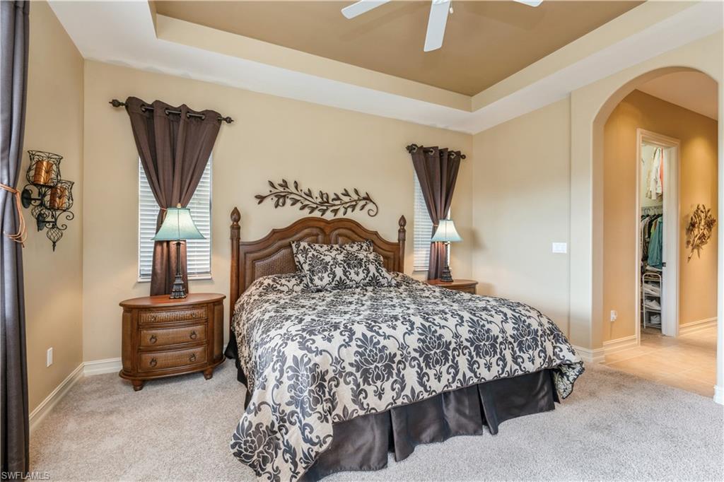 1411 Serrano Circle Naples, FL 34105 - Photo 27 of 50 Bedroom featuring a raised ceiling, ceiling fan, a closet, and light colored carpet