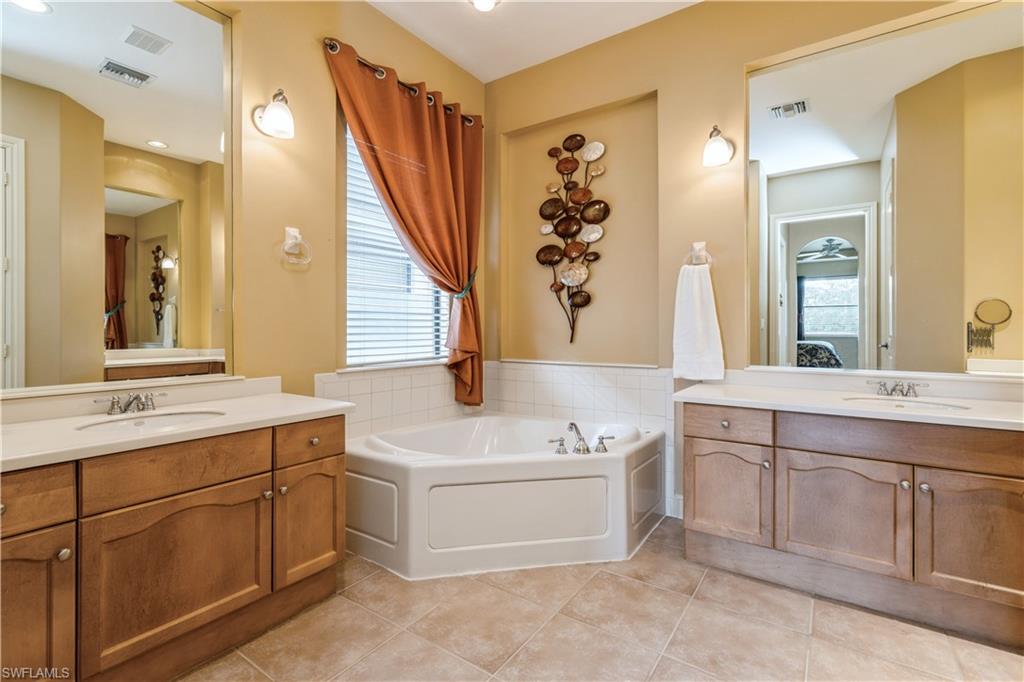 1411 Serrano Circle Naples, FL 34105 - Photo 30 of 50 Bathroom featuring tile patterned flooring, vanity, and a tub