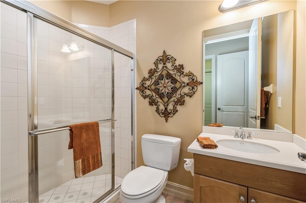1411 Serrano Circle Naples, FL 34105 - Photo 36 of 50 Bathroom with vanity, toilet, and an enclosed shower