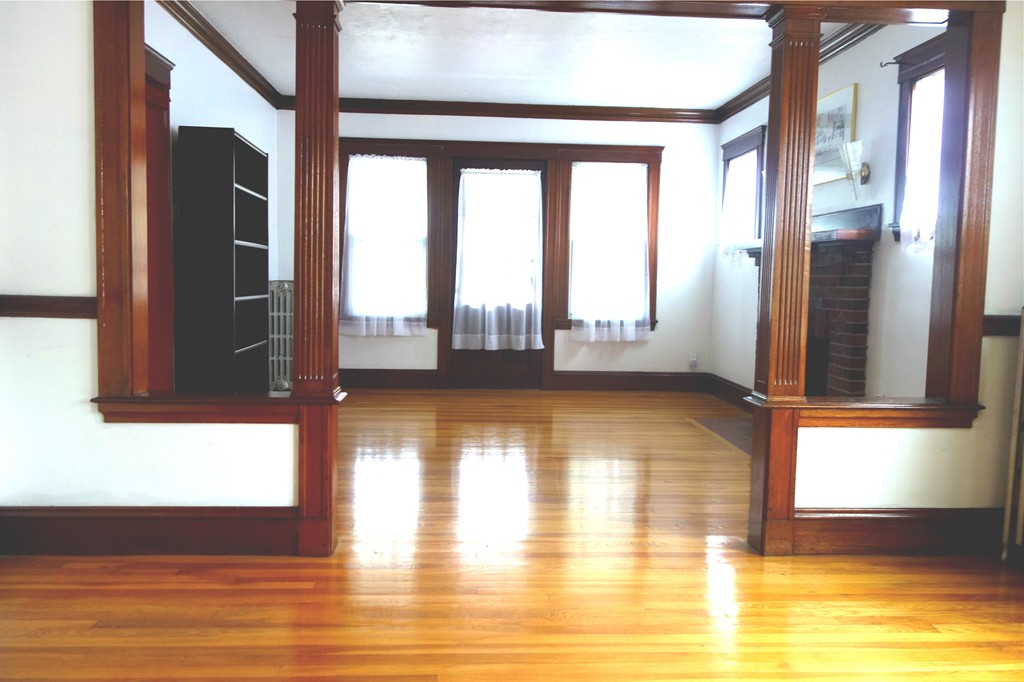 a view of empty room with wooden floor and floor to ceiling window