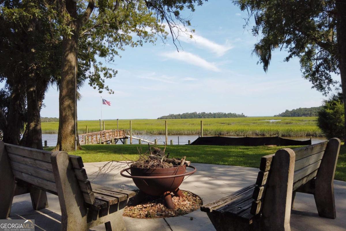 2061 Belle Island Road Richmond Hill, GA 31324 - Photo 45 of 49 a view of a chairs and table in patio with a lake view