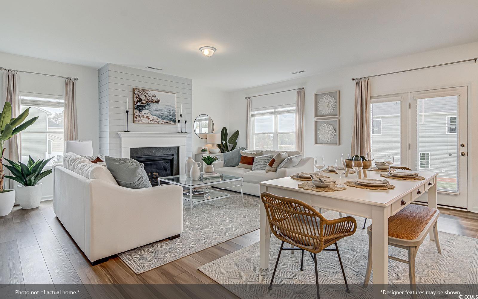 312 Garden Grove Street Conway, SC 29526 - Photo 4 of 8 Dining space featuring light wood finished floors, a glass covered fireplace, and healthy amount of natural light