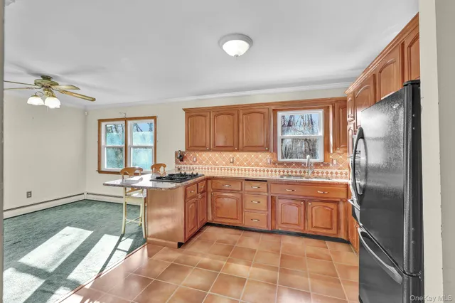 a view of a dining room with furniture a chandelier and large windows