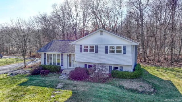 a front view of a house with a yard and potted plants