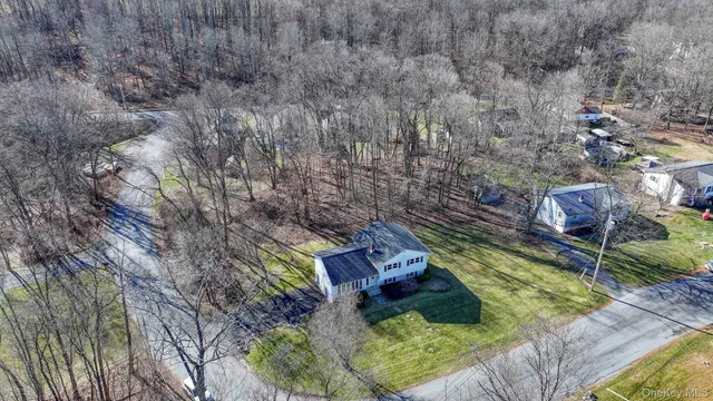 a view of a house with a big yard and large trees