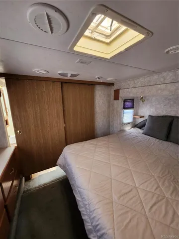 a bedroom with a large bed and a chandelier