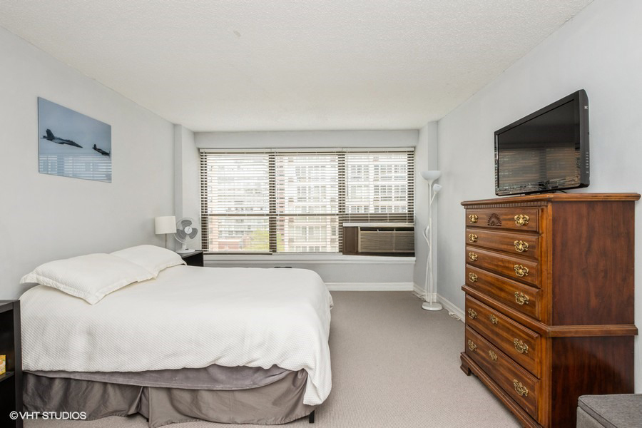 2930 North Sheridan Road, Unit 1008 Chicago, IL 60657 - Photo 5 of 12 a bedroom with a bed and flat screen tv