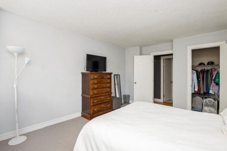 2930 North Sheridan Road, Unit 1008 Chicago, IL 60657 - Photo 6 of 12 a bedroom with a bed and a television